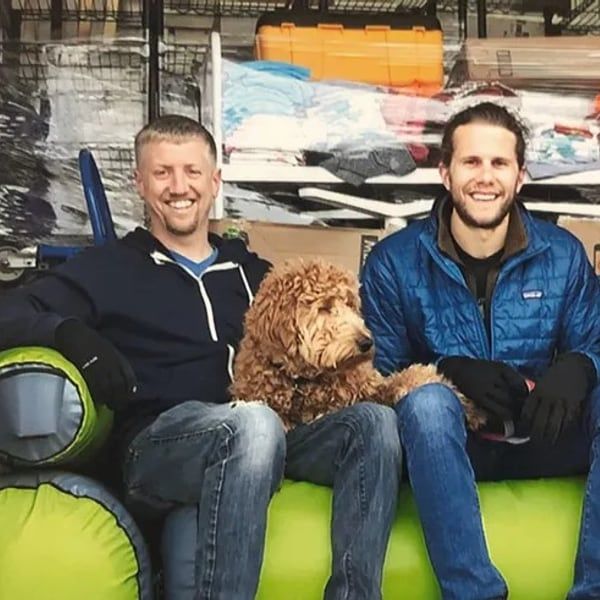 Brian and Bryan on a couch with their dog